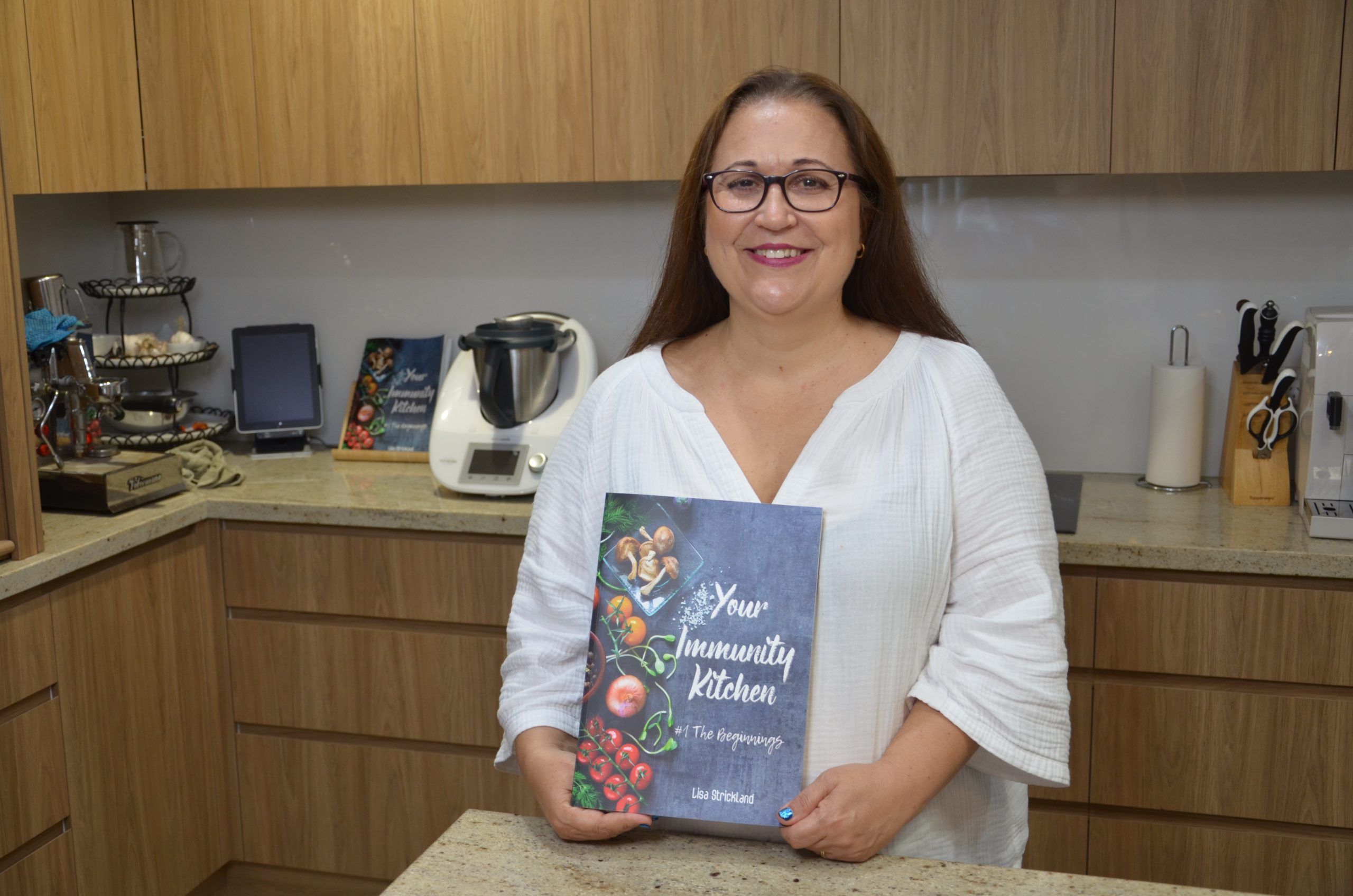 Lisa holding Your Immunity Kitchen book